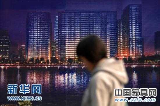 一位市民從杭州市區(qū)的一處商業(yè)樓盤廣告牌前走過(guò)（2010年11月4日攝）。新華社記者 黃宗治 攝 